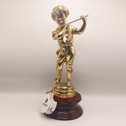 Figura decorativa de un niño tocando la flauta