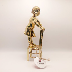 Figura decorativa de una niña en una silla